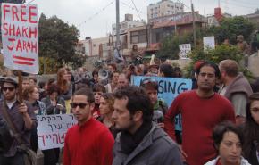 Protesters stand in the back yard of a house now occupied by Israeli settlers in the Sheikh Jarrah neighborhood