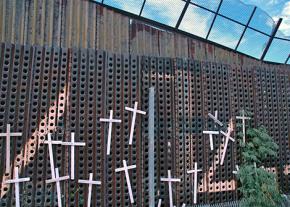 A section of the border wall in Nogales, Ariz., with crosses to memorialize people who died attempting to cross